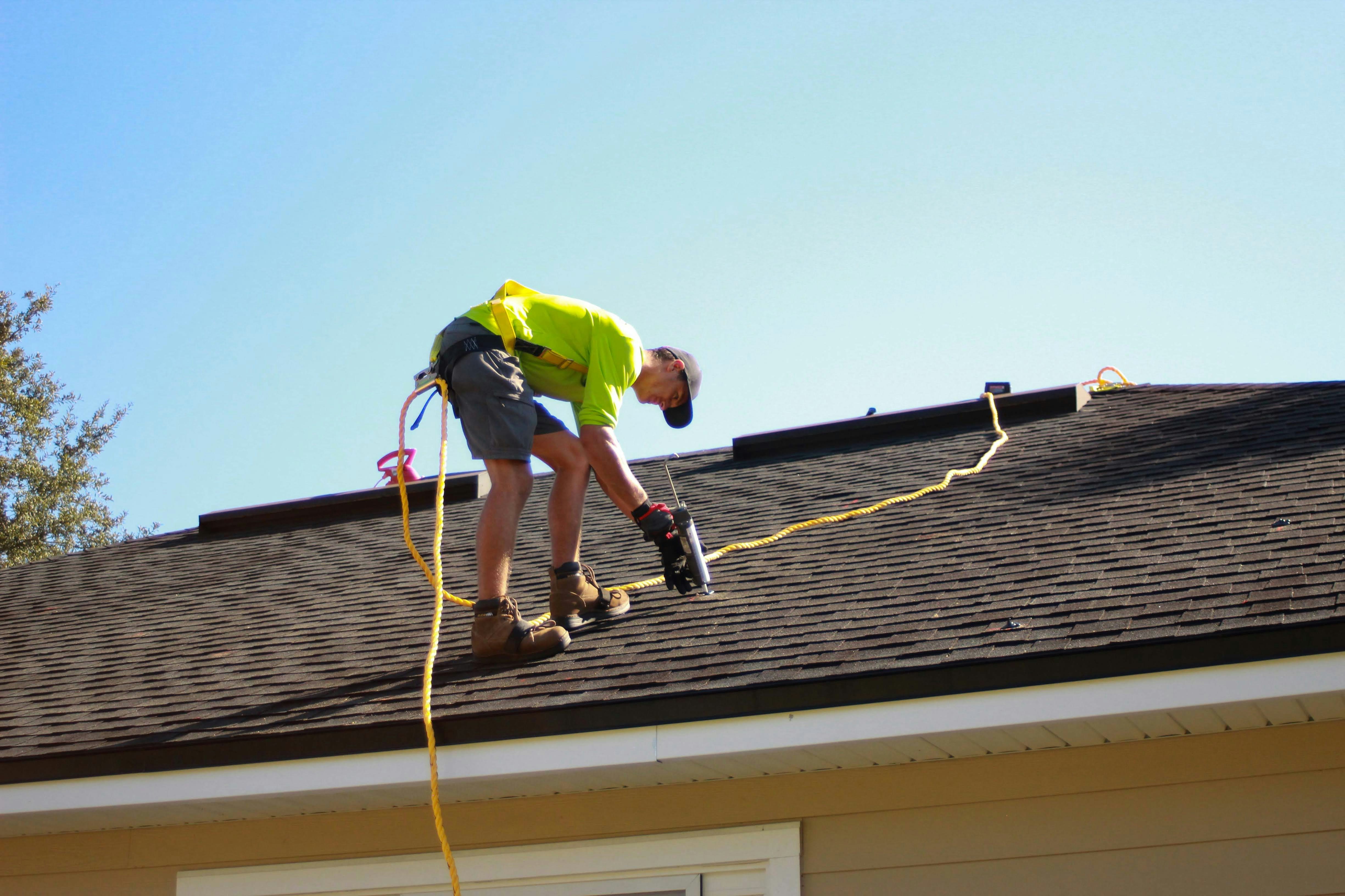 Professional roofer working on shingle roof